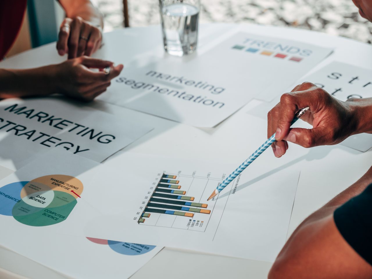 A team in an office meeting developing a marketing strategy with data charts and documents.